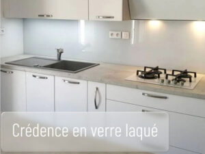 Crédence de cuisine en verre laqué installée entre le plan de travail et les meubles hauts.
