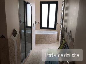Porte de douche vitrée sur mesure dans une salle de bain contemporaine.